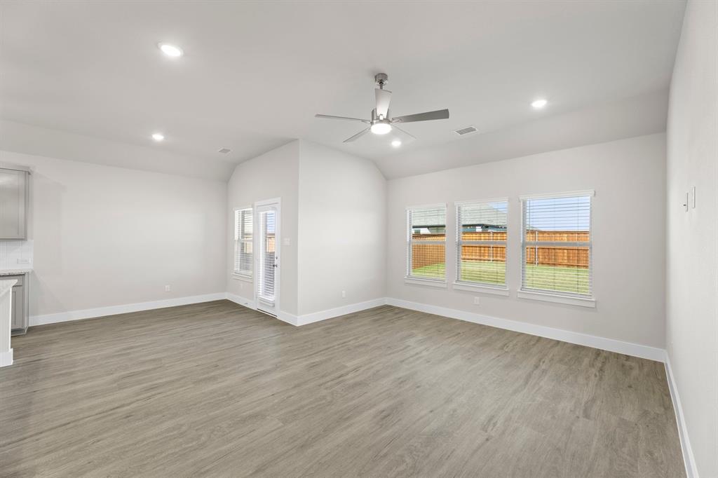 2372 Bell Way Forney, TX 75126 - Photo 6 of 39 an empty room with wooden floor ceiling fan and windows