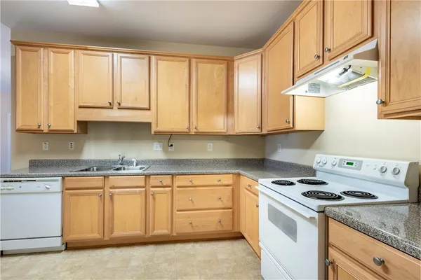 a kitchen with granite countertop white cabinets and white appliances