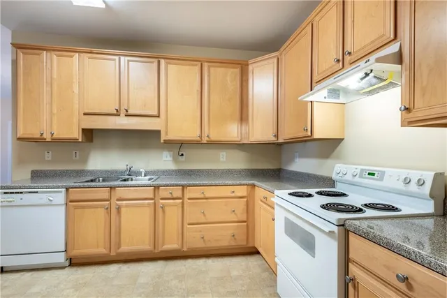 a kitchen with granite countertop white cabinets and white appliances