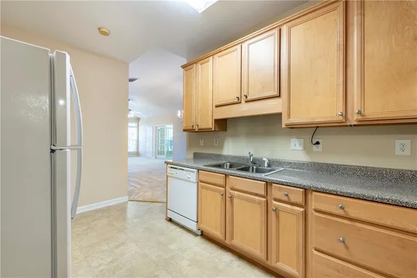 a kitchen with stainless steel appliances granite countertop a sink a refrigerator and cabinets