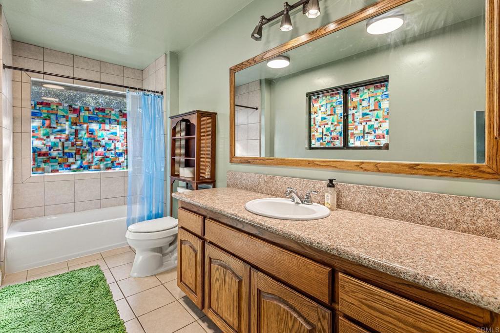 8411 Foothill Boulevard Pine Valley, CA 91962 - Photo 22 of 46 a bathroom with a granite countertop sink mirror vanity bathtub and a toilet
