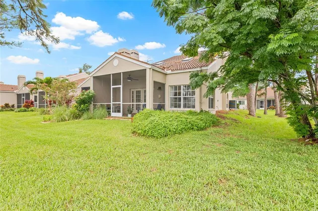 an aerial view of residential houses with outdoor space and lake view in back