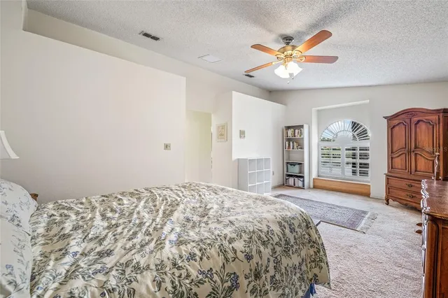 a bedroom with a large bed and a chandelier