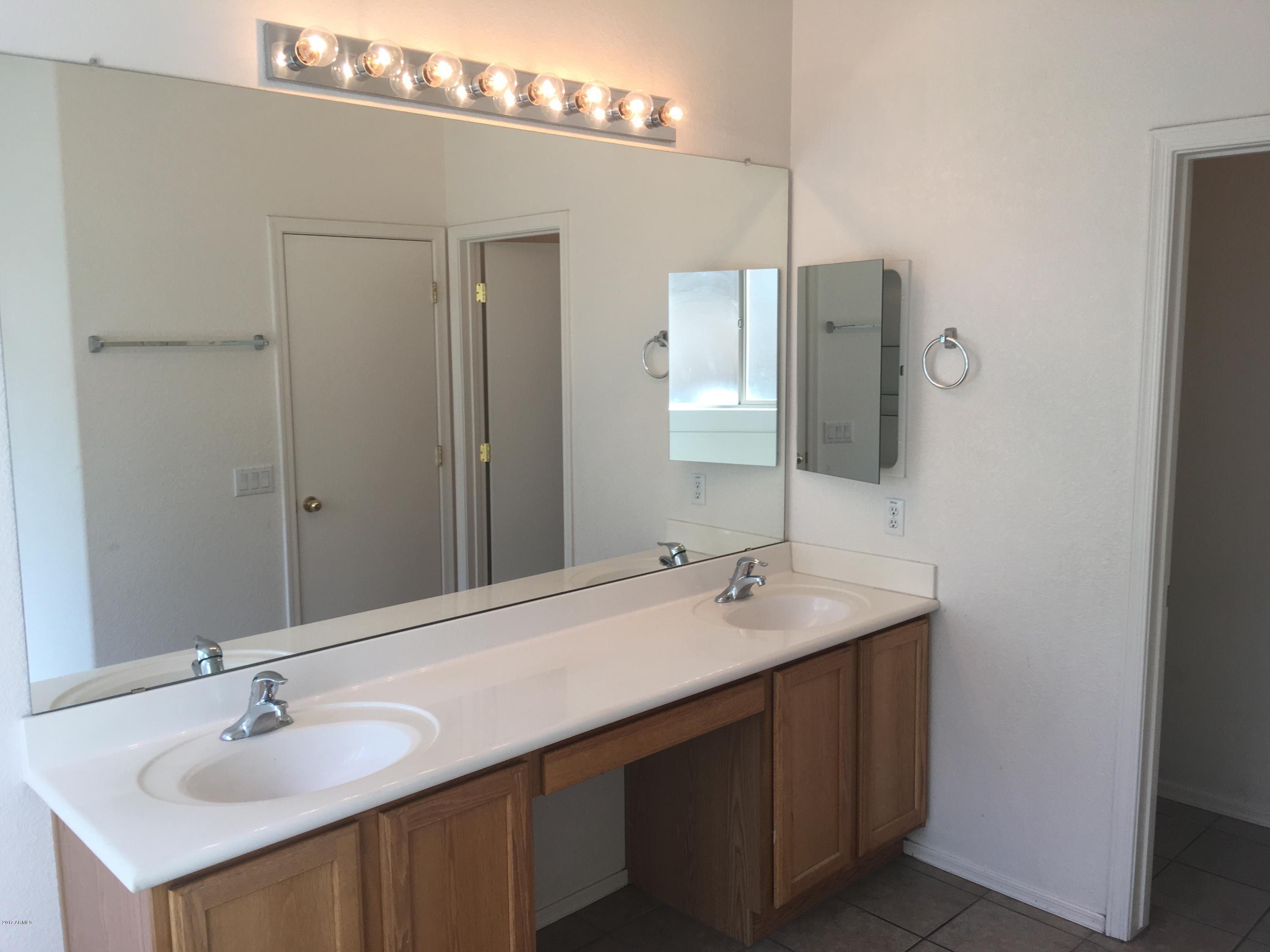 9128 West Berkeley Road Phoenix, AZ 85037 - Photo 12 of 17 a bathroom with a sink and a mirror