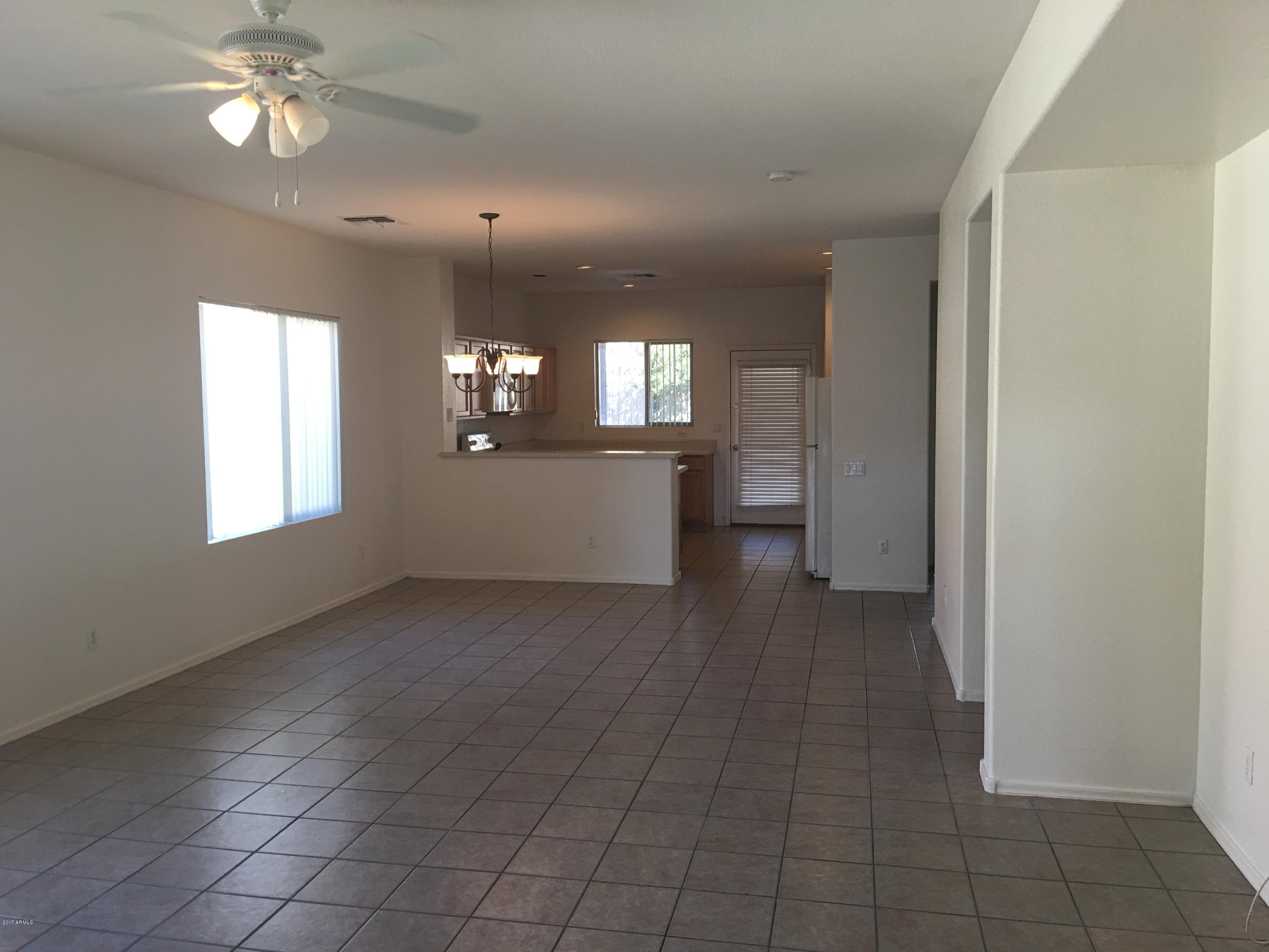 9128 West Berkeley Road Phoenix, AZ 85037 - Photo 3 of 17 wooden floor in an empty room with a window
