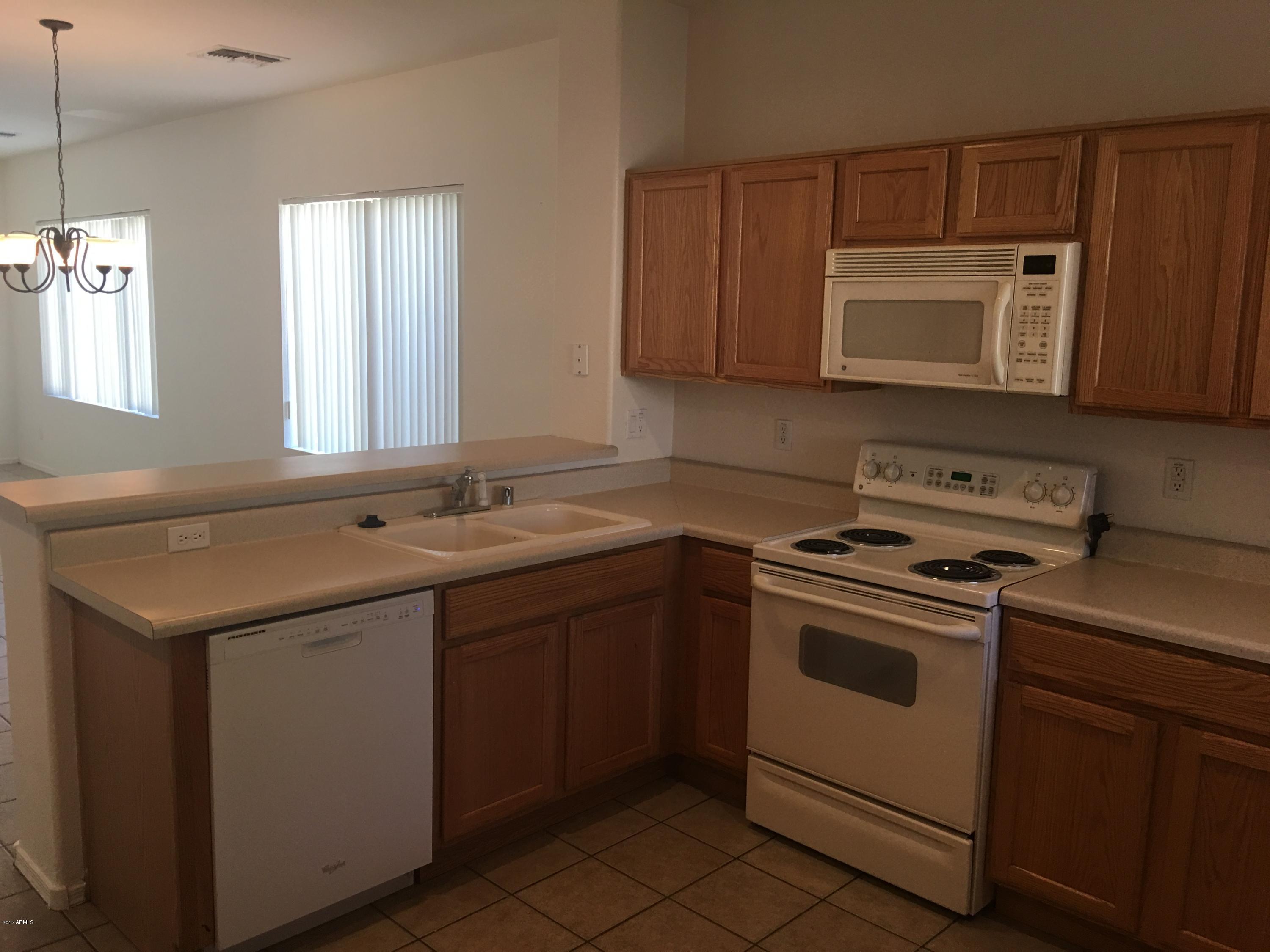 9128 West Berkeley Road Phoenix, AZ 85037 - Photo 5 of 17 a kitchen with a sink stove and microwave