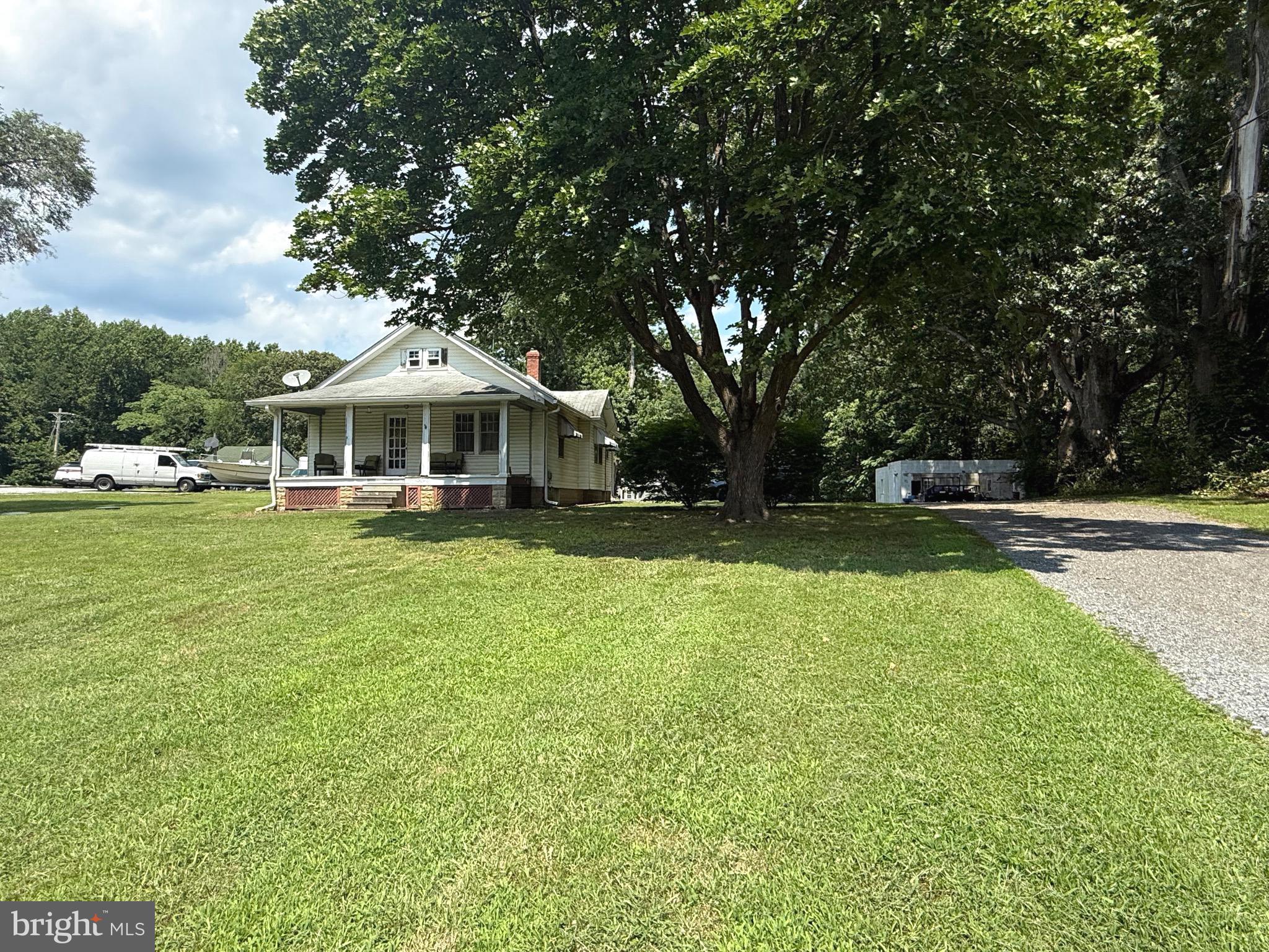 9860 H G Trueman Road Lusby, MD 20657 - Photo 1 of 12 a front view of a house with a yard table and chairs