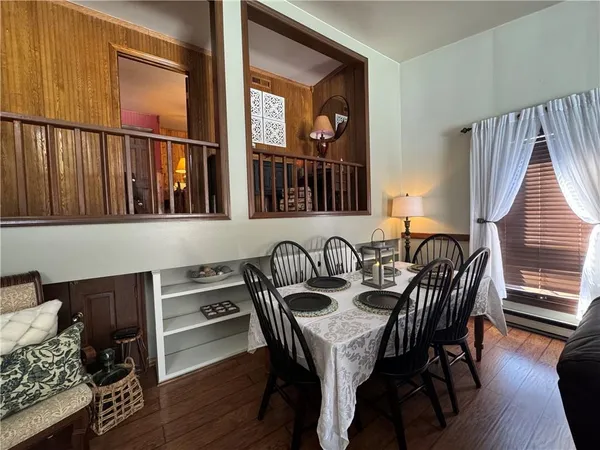 a view of a a dining room with furniture window and wooden floor