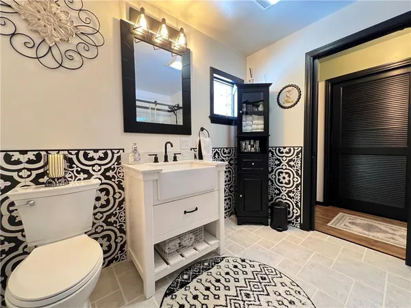 a bathroom with a toilet a sink and mirror