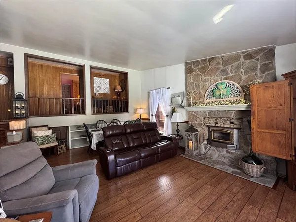 a living room with furniture a fireplace and a floor to ceiling window
