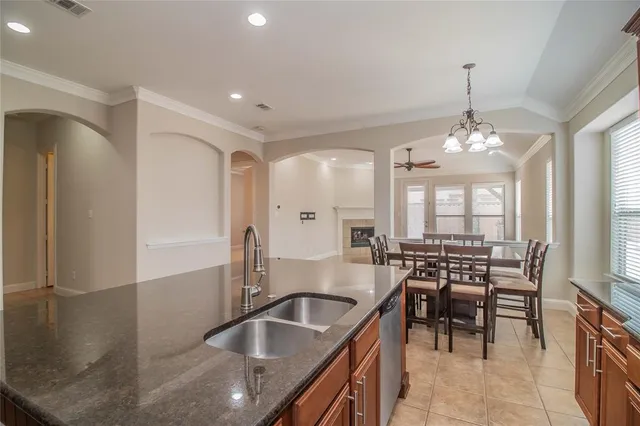 a kitchen with granite countertop a sink a counter top space and stainless steel appliances