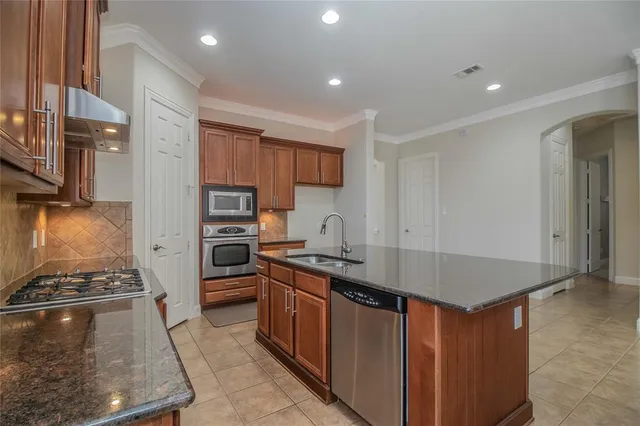 a kitchen with stainless steel appliances granite countertop a stove a sink and a refrigerator