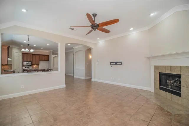 a view of an empty room and a kitchen