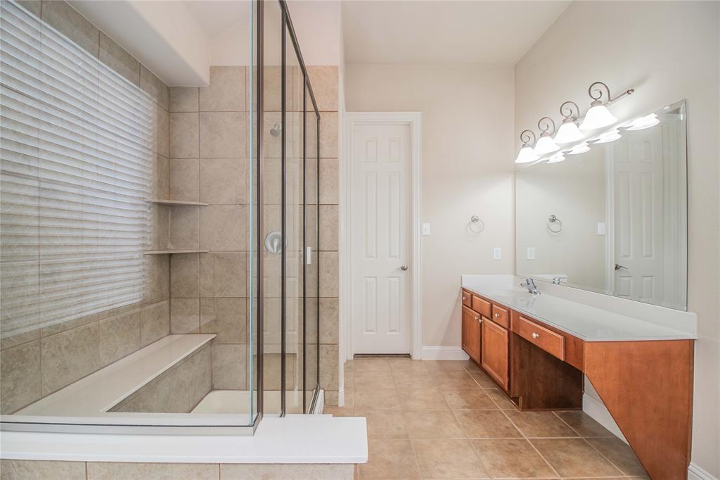 4647 Phillip Drive Plano, TX 75024 - Photo 23 of 38 a bathroom with a granite countertop sink a mirror and a bathtub