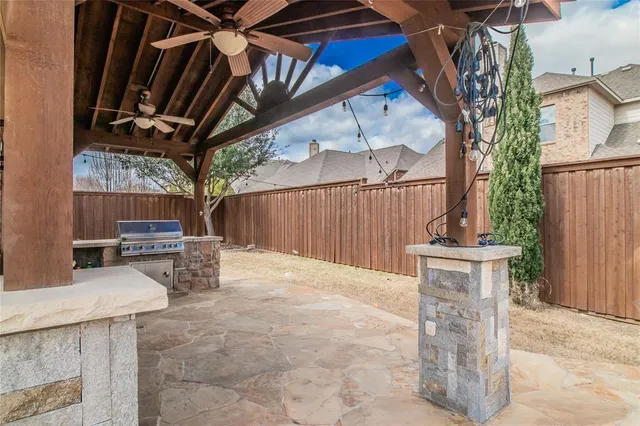 a view of a backyard with table and chairs with wooden fence