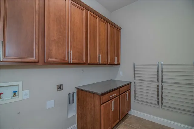 a utility room with granite countertop wooden cabinets