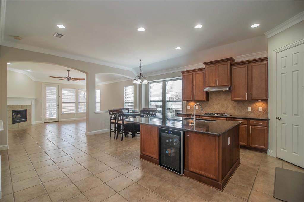 4647 Phillip Drive Plano, TX 75024 - Photo 8 of 38 a kitchen with stainless steel appliances granite countertop a stove top oven a sink dishwasher a dining table and chairs with wooden floor