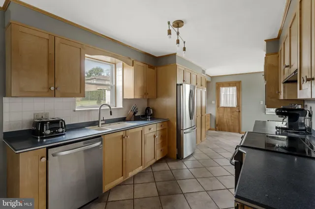 a kitchen with stainless steel appliances granite countertop a sink stove and cabinets