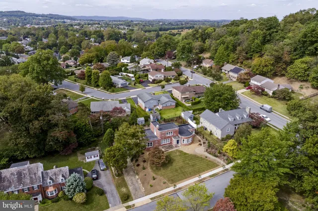 an aerial view of residential houses with outdoor space and parking