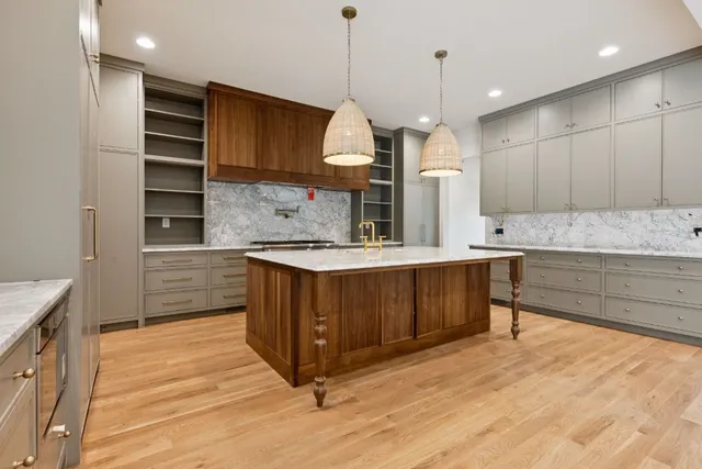 a kitchen with kitchen island granite countertop a sink a counter space appliances and cabinets