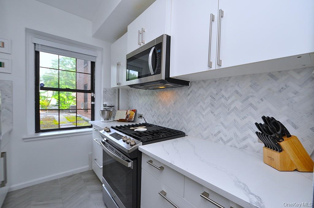 192 Garth Road, Unit TP Scarsdale, NY 10583 - Photo 2 of 43 The thoughtfully renovated kitchen is a chef’s delight, showcasing stainless steel appliances, custom white cabinetry, abundant quartz countertops, and generous workspace.