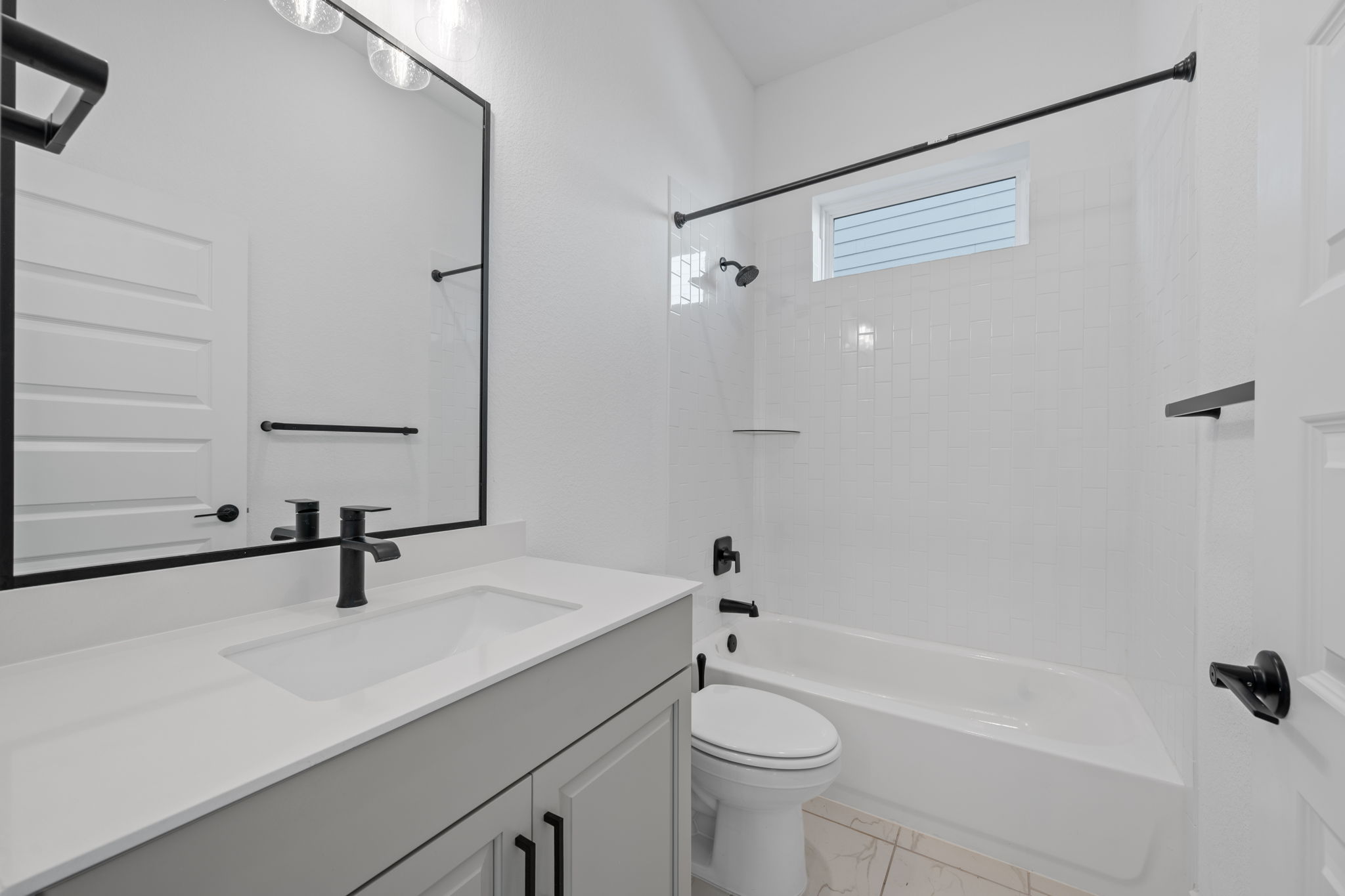 5902 Rangeland Road Austin, TX 78747 - Photo 16 of 35 Bathroom with vanity, bathing tub / shower combination, and light marble finish floors