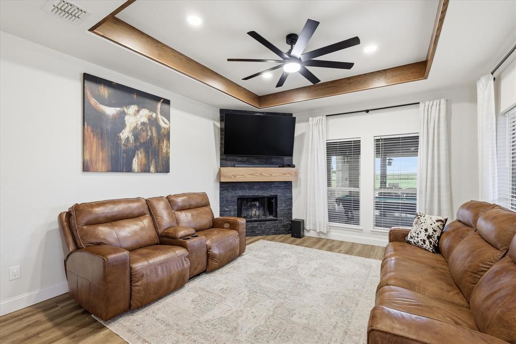 430 Ridgecrest Place Sanger, TX 76266 - Photo 6 of 40 Living area featuring a tiered ceiling with wood-finish accents, recessed lighting, and a modern ceiling fan