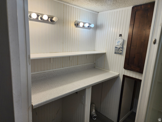 332 Joshua Street Tooele, UT 84074 - Photo 5 of 16 Compact utility space featuring white beadboard paneling, two wall-mounted vanity lights, and a light-colored countertop