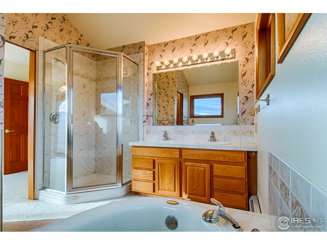 601 Eagle Ridge Road Longmont, CO 80503 - Photo 36 of 40 a bathroom with a sink a mirror and a shower