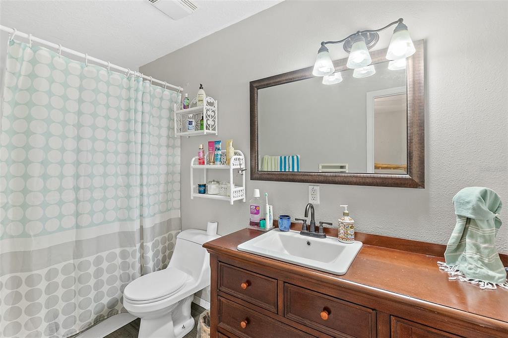 405 North Cherry Street Bunnell, FL 32110 - Photo 12 of 52 a bathroom with a sink a toilet a mirror and shower curtain