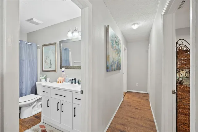 a bathroom with a sink mirror and a toilet