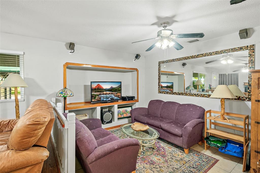 405 North Cherry Street Bunnell, FL 32110 - Photo 18 of 52 a living room with furniture a ceiling fan and a flat screen tv