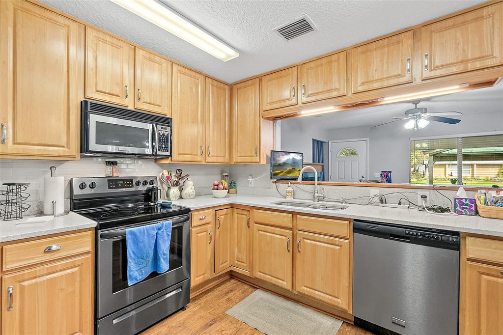 405 North Cherry Street Bunnell, FL 32110 - Photo 20 of 52 a kitchen with stainless steel appliances granite countertop a sink stove microwave and cabinets