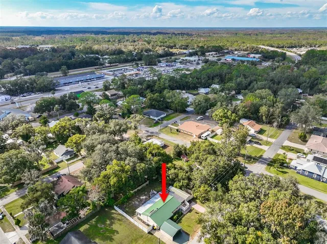 an aerial view of residential houses with outdoor space and ocean view
