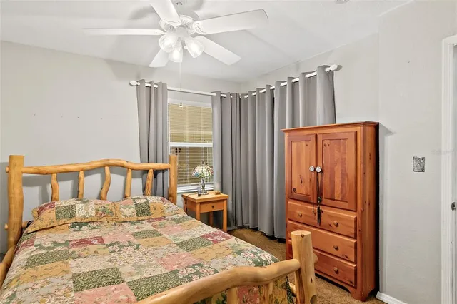 a bedroom with a bed a dresser and a chandelier