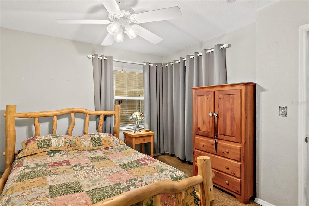 405 North Cherry Street Bunnell, FL 32110 - Photo 10 of 52 a bedroom with a bed a dresser and a chandelier