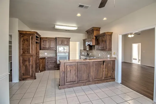 a kitchen with stainless steel appliances kitchen island granite countertop a refrigerator and a sink
