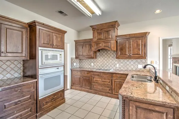 a kitchen with granite countertop cabinets and steel stainless steel appliances