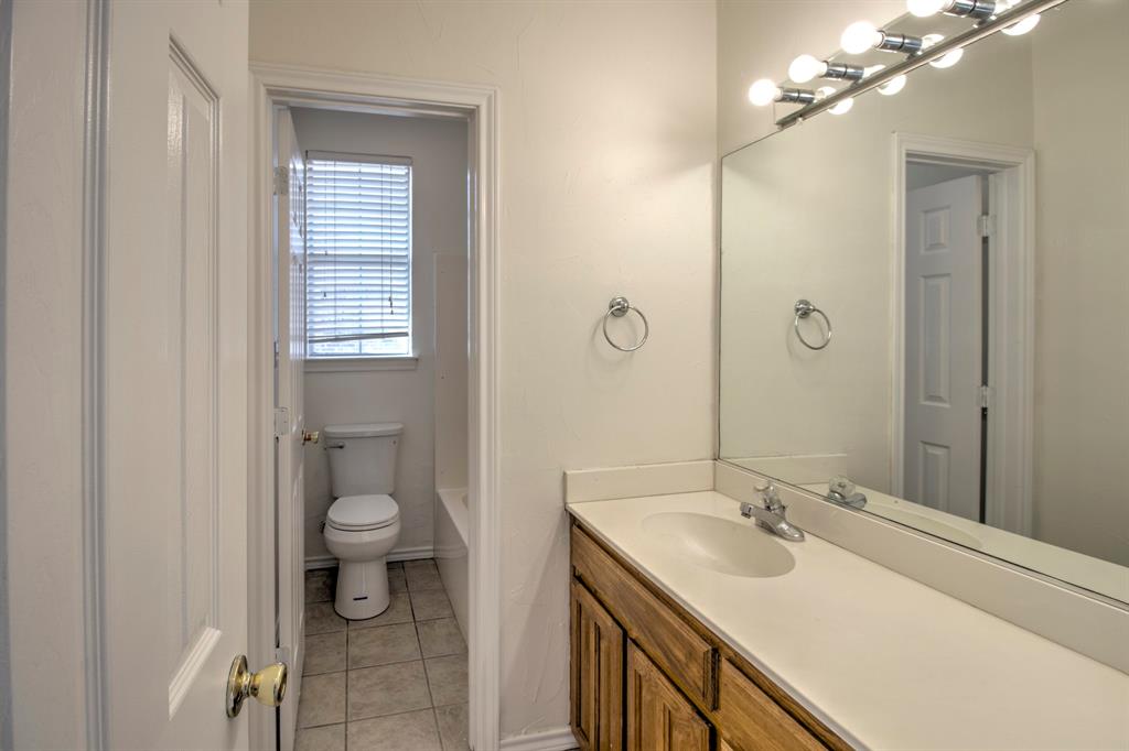 1400 North St Charles Street Pilot Point, TX 76258 - Photo 22 of 30 a bathroom with a sink toilet and shower