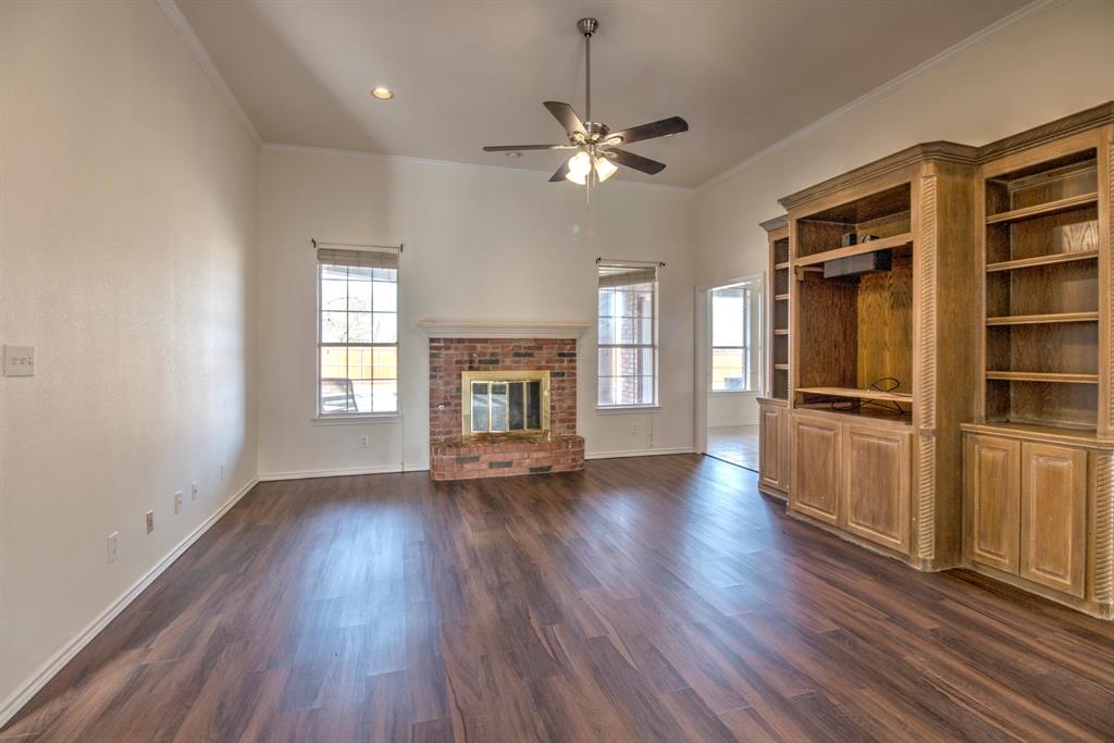 1400 North St Charles Street Pilot Point, TX 76258 - Photo 9 of 30 an empty room with wooden floor fireplace and windows