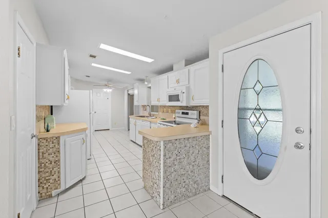 a kitchen with white cabinets appliances and a sink