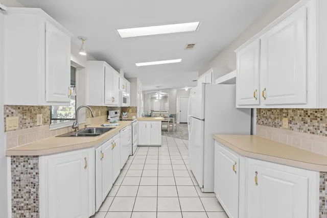 a kitchen with white cabinets and white appliances