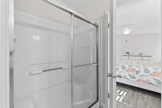 a bedroom with a bed a dresser and a chandelier