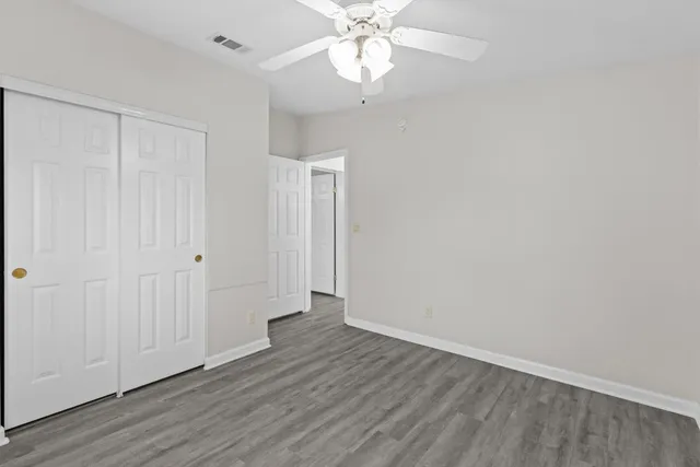 a front view of a house with garden and tree