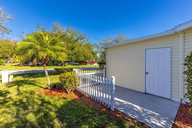 a sign that is sitting on a brick wall and trees around