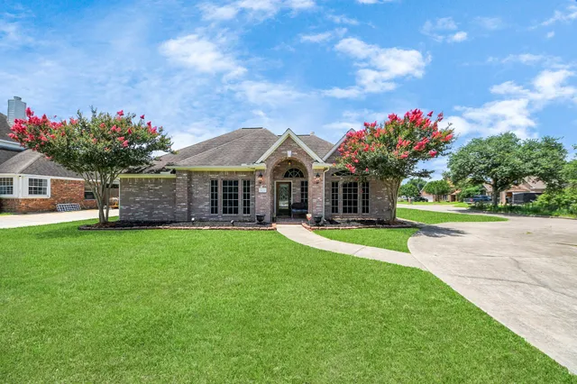 a front view of a house with a big yard and a large tree