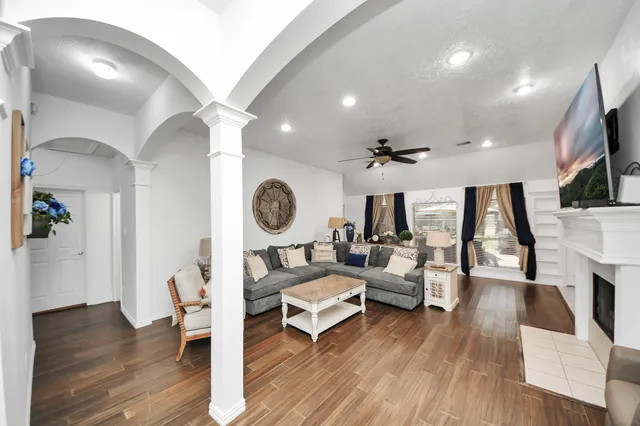 a living room with furniture a wooden floor and a large window