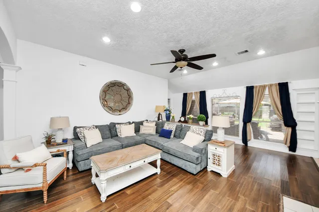 a living room with furniture and a wooden floor