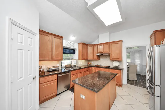 a kitchen with stainless steel appliances granite countertop a refrigerator and a stove top oven