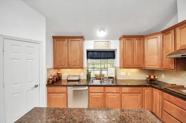 a kitchen with a stove a refrigerator and a dining table with wooden floor